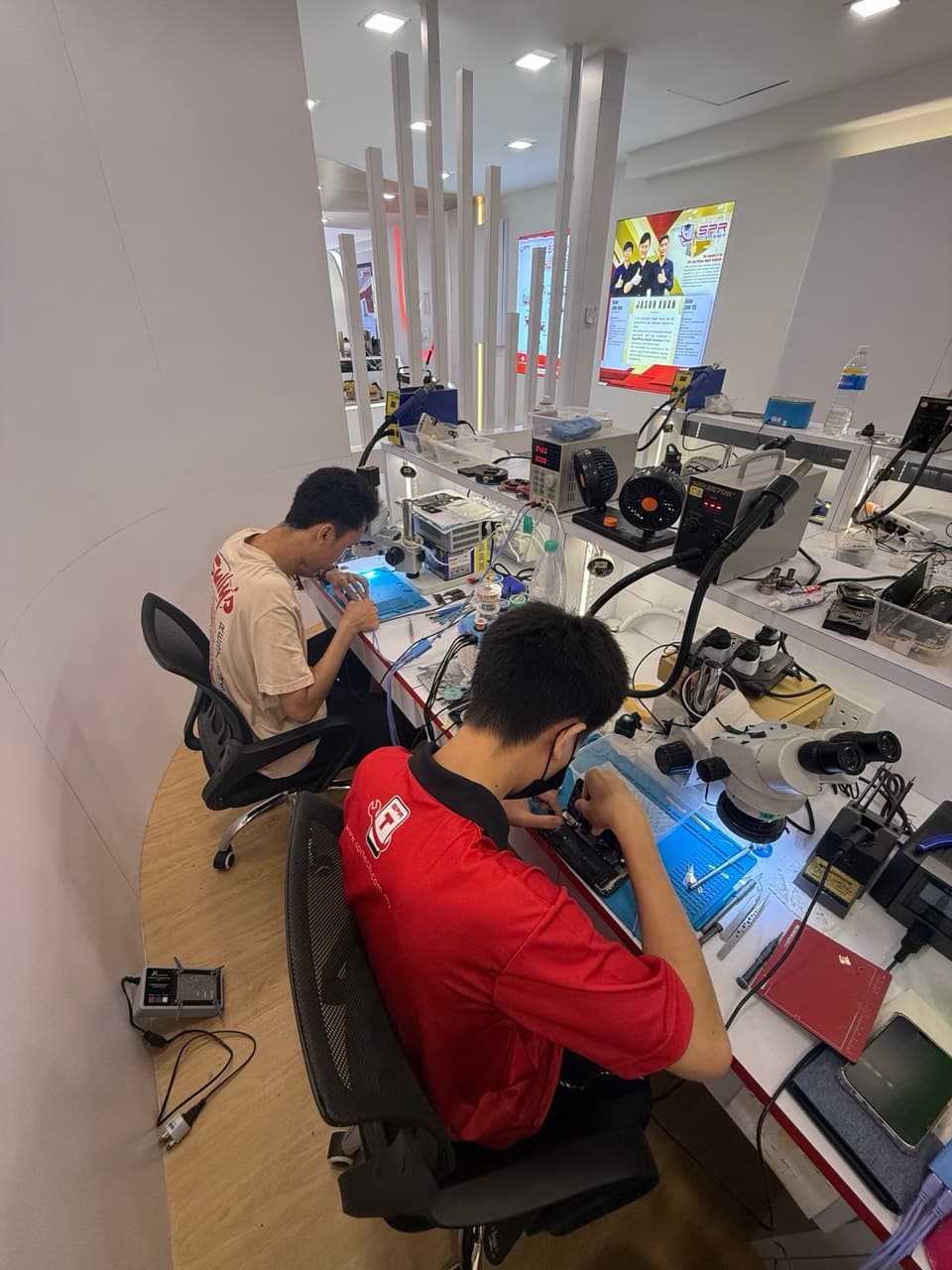Top-down view of students soldering at workbench