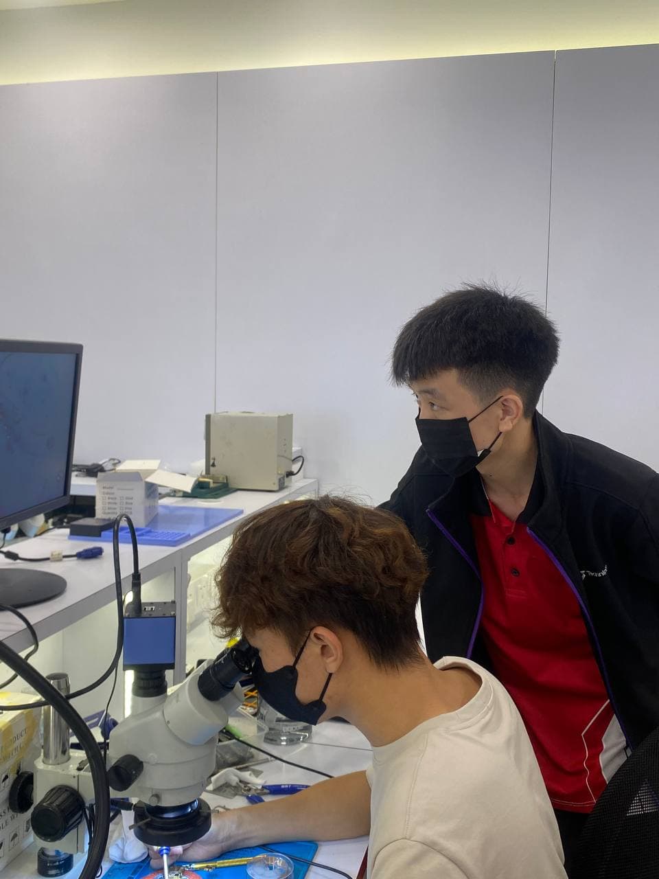 学员显微镜作业,导师在旁观察