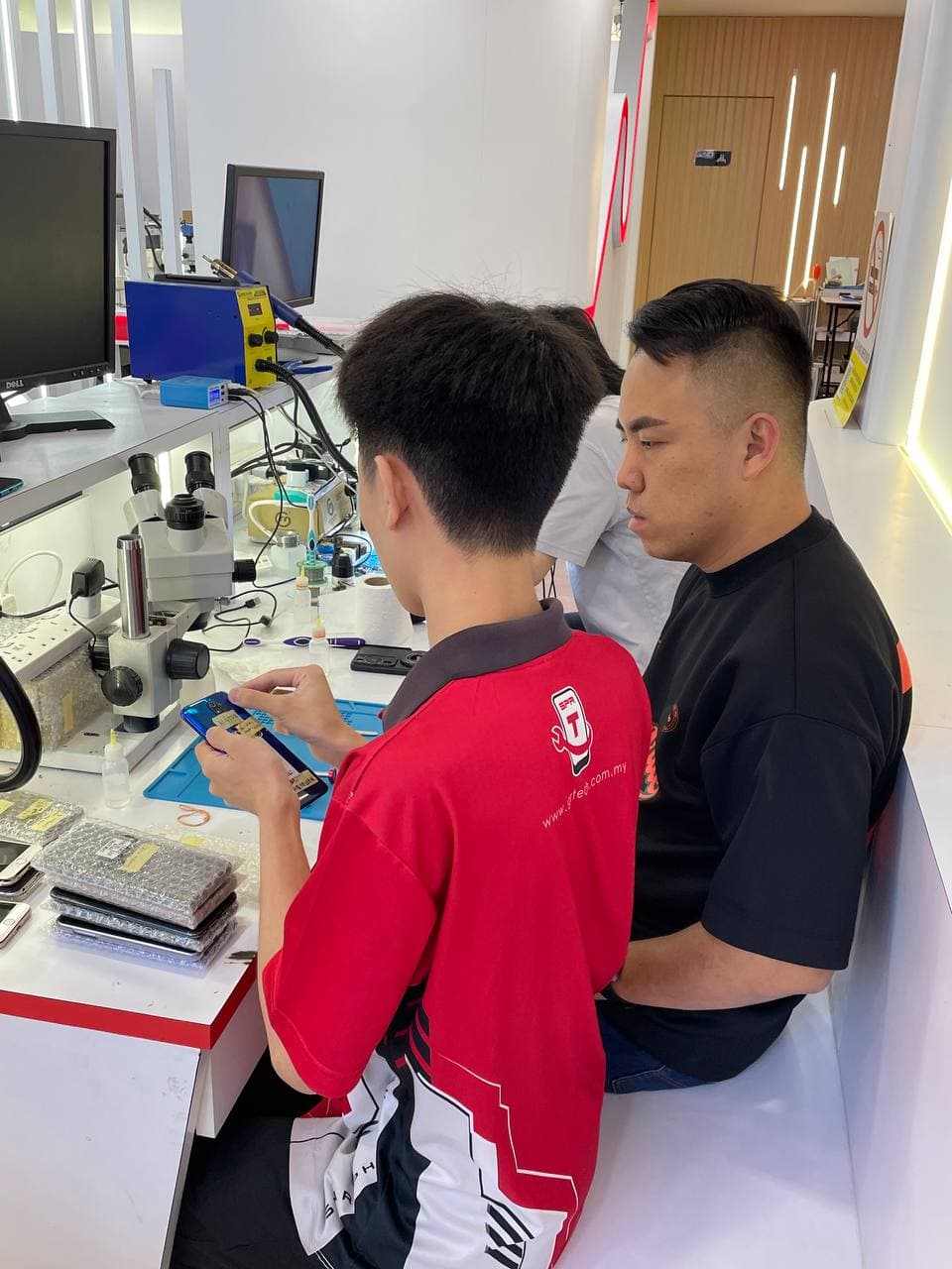 两名学员对照学习手机维修